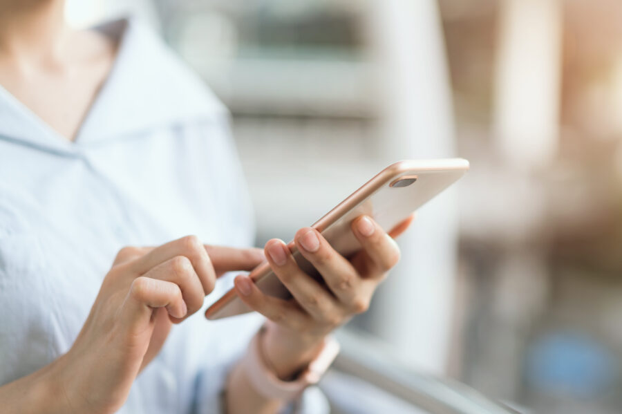 woman using smartphone on staircase in public areas, During leisure time. The concept of using the phone is essential in everyday life.